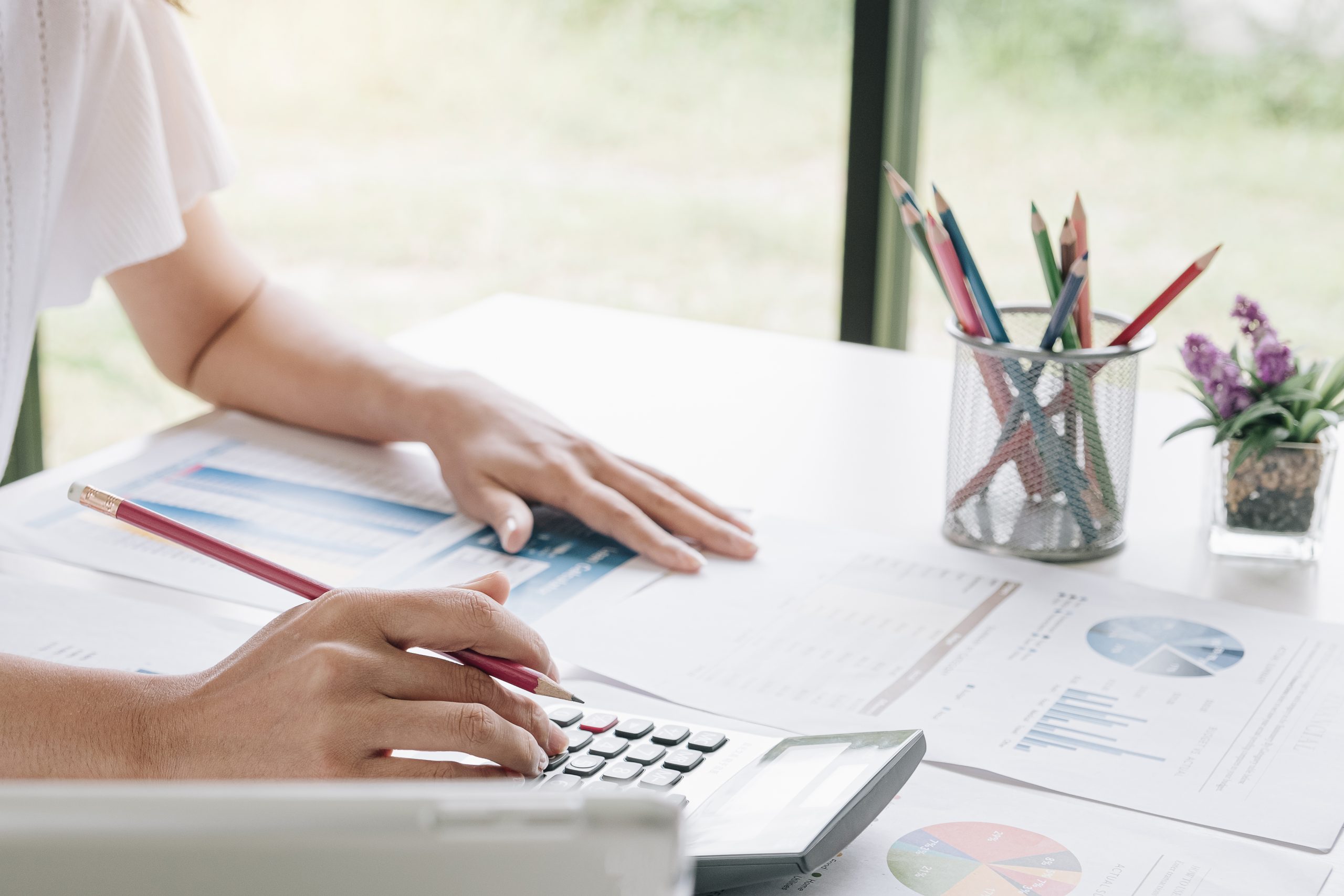 Business woman using calculator and laptop for do math finance o